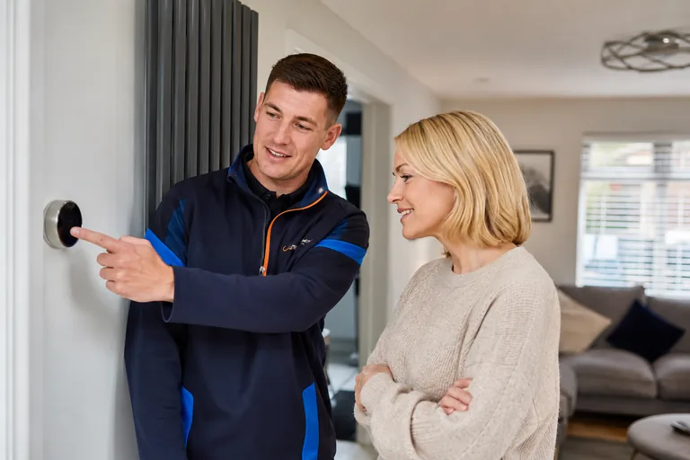 Illustrative heating engineer explaining wall controls to a customer.